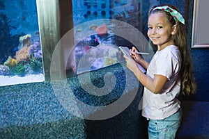 Cute girl looking at fish tank