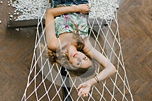 Cute girl lying on a hammock, resting and smiling