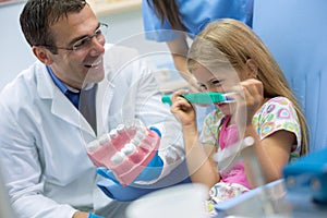 Cute girl make joke with her dentist in dental clinic