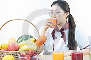 A cute girl makes vegetable juice, with carrot apple orange cranberry beetroot and mango in chef suit