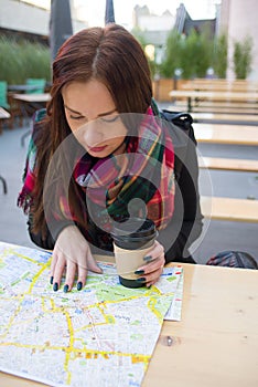 Cute girl with map at open cafe