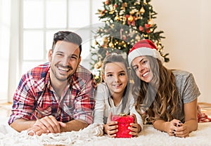 Cute girl opening a magical present on a Christmas morning with her family
