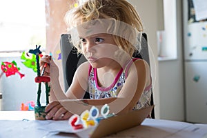 Cute girl painting wooden giraffe push puppet.