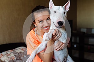 Cute girl petting her bull terrier .Beautiful girl having fun with her bull terrier and enjoying herself. Girl and her