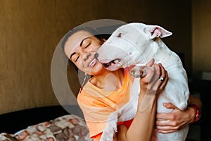 Cute girl petting her bull terrier .Beautiful girl having fun with her bull terrier and enjoying herself. Girl and her