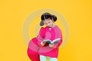 Cute girl with pigtail hair reading a book