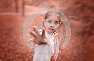 Cute girl with pigtails among the leaves in the forest