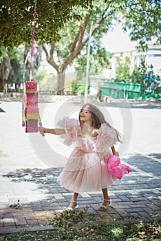 Cute girl in a pink puffy dress in the park