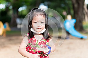 Cute girl played in playground until she was tired. Asian child sweats on the temples. Children smiles sweet. In summer or spring