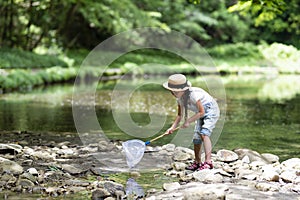 Cute girl playing in a beautiful mountain stream