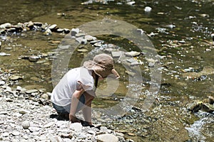 Cute girl playing in a beautiful mountain stream