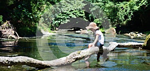 Cute girl playing in a beautiful mountain stream