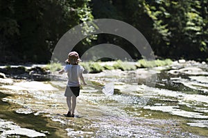 Cute girl playing in a beautiful mountain stream