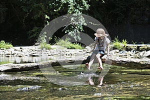 Cute girl playing in a beautiful mountain stream