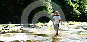 Cute girl playing in a beautiful mountain stream