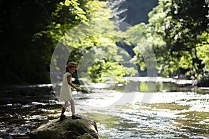 Cute girl playing in a beautiful mountain stream