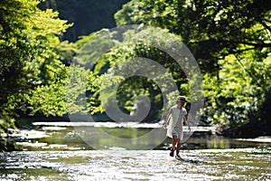 Cute girl playing in a beautiful mountain stream