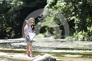 Cute girl playing in a beautiful mountain stream