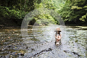 Cute girl playing in a beautiful mountain stream