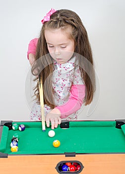 Cute girl playing billiard