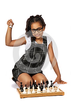 Cute girl playing chess on white