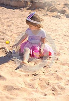 Cute girl playing with easter eggs on the beach