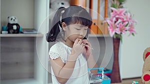 Cute girl playing with food toy and large teddy bear