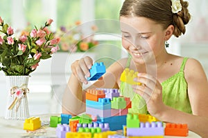 Cute girl playing with plastic blocks