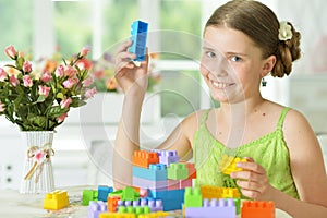Cute girl playing with plastic blocks