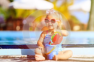 Cute girl playing in swimming pool at the beach