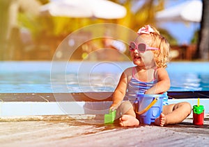 Cute girl playing in swimming pool at beach