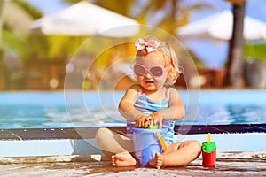 Cute girl playing in swimming pool at beach