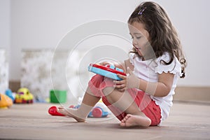 Cute girl playing with toy guitar at home