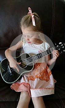 Cute girl playing ukulele