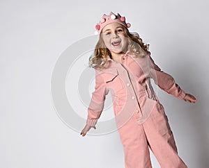 cute girl with a plush crown, standing upright in a dusty rose cotton summer jumpsuit with comfortable pockets. on a