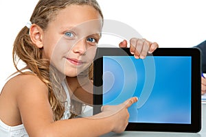 Cute girl pointing on blank tablet screen.