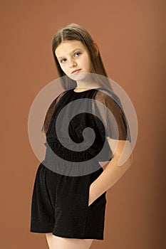 Cute girl posing in black jumpsuit. Photo session in the studio