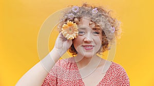 Cute Girl Posing With Orange Gerbera Daisy Flower Over Bright Yellow Background