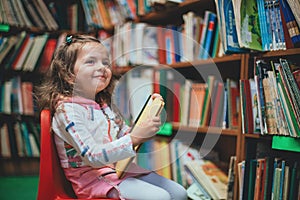 Cute girl reading book in library