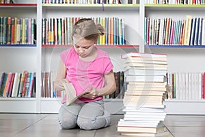 Cute girl reading book in library