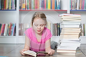 Cute girl reading book in library