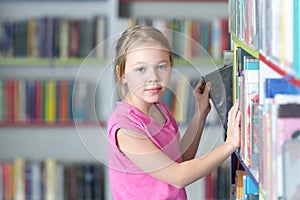 Cute girl reading book in library