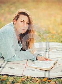 Cute girl reading a book in park