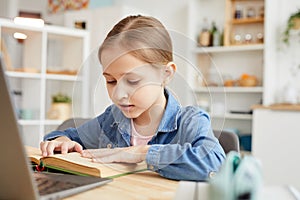 Cute Girl Reading Book to Online Teacher