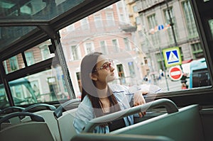 Cute girl rides in a tourist sightseeing bus.