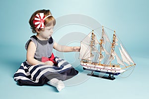 Cute girl sailor with model ship
