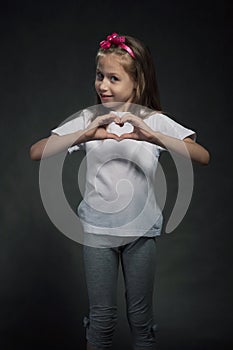 Cute girl showing heart shaped sign