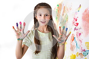 Cute girl shows paint stained hands on white
