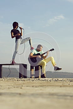 Cute girl singing with handsome man pointing at blue sky