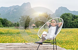 Cute girl sit and relax on chair and yellow flower background